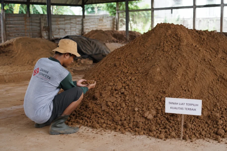 Proses pemilihan bahan baku tanah liat berkualitas terbaik untuk produksi gerabah di Darma Semesta.
